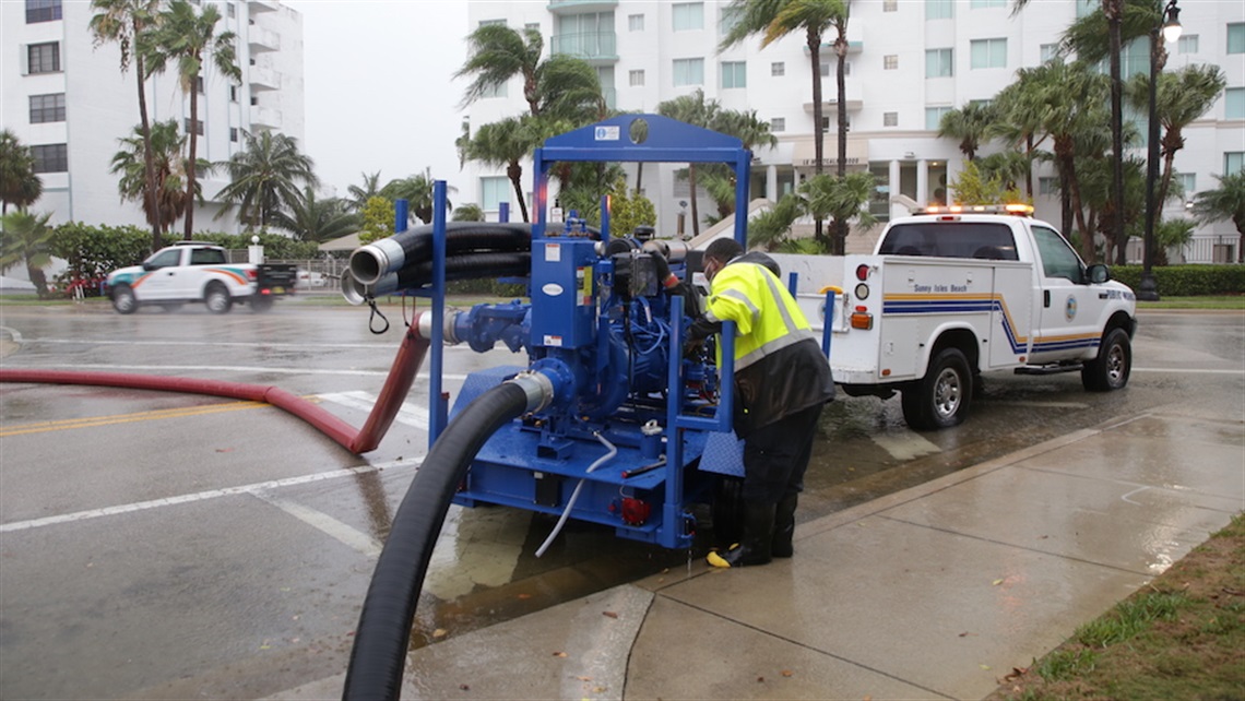 Public Works staff deploying a portable pump in the street.