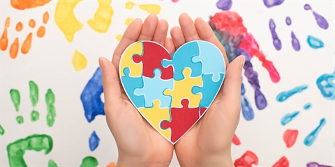 Hand holding puzzle pieces of heart