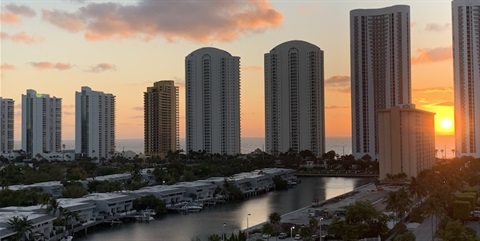 sun setting behind high rise buildings