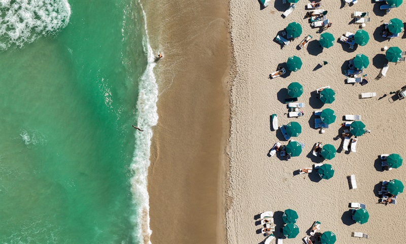 Aerial view of beach loungers and ocean.